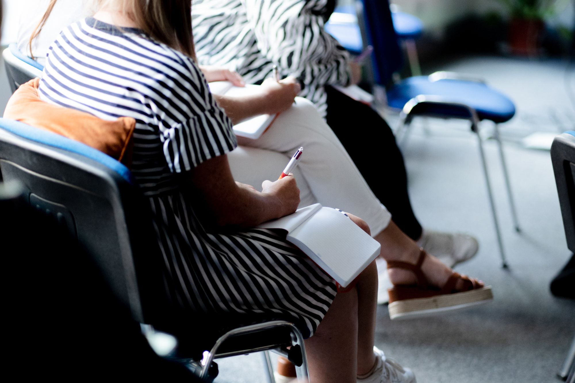 An office worker writing in a notebook in an office setting